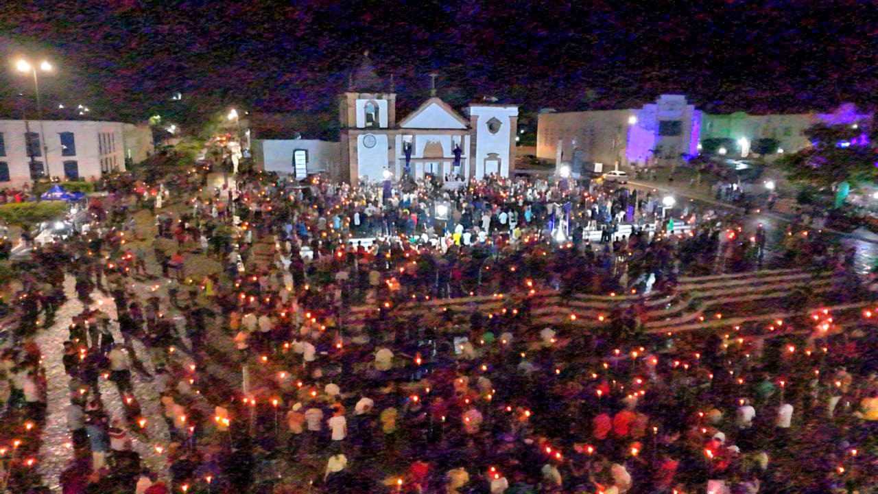 Foto do alto, onde se vê a igreja de Nossa Senhora da Vitória e a praça cheia de homes com lamparina nas mão - as famosas tochas do fogaréu